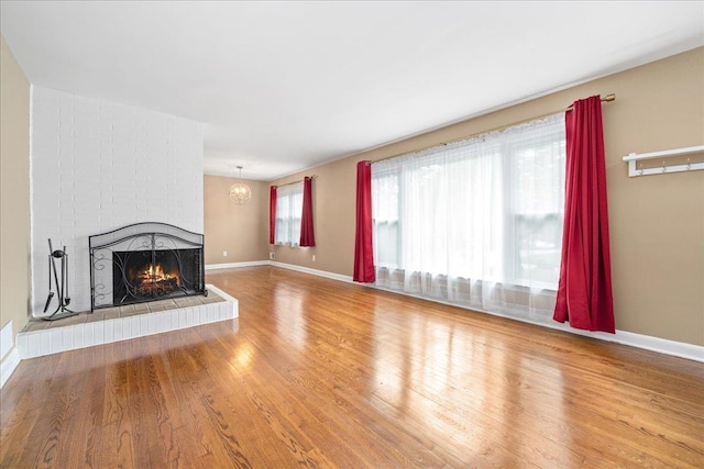 222 Woodview, Spartanburg, SC 29306 - unfurnished living room featuring a brick fireplace, wood finished floors, and baseboards