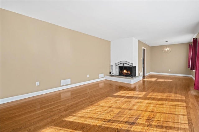 222 Woodview, Spartanburg, SC 29306 - unfurnished living room featuring wood finished floors, a multi sided fireplace, a chandelier, and baseboards