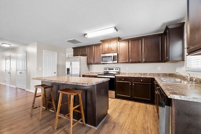 325 Victory, Moore, SC 29369 - kitchen with stainless steel appliances, light wood-style floors, a center island, a sink, and a kitchen breakfast bar