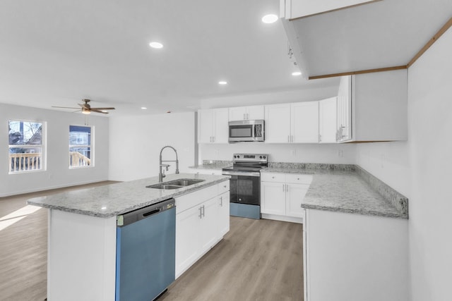514 N Forest, Spartanburg, SC 29303 - kitchen featuring appliances with stainless steel finishes, a sink, light wood-type flooring, white cabinetry, and an island with sink
