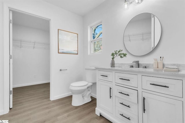 514 N Forest, Spartanburg, SC 29303 - bathroom with toilet, vanity, wood finished floors, baseboards, and a spacious closet