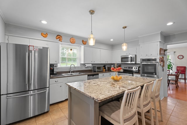302 Peach Vly, Spartanburg, SC 29303 - kitchen featuring appliances with stainless steel finishes, a sink, light tile patterned floors, white cabinets, and a center island