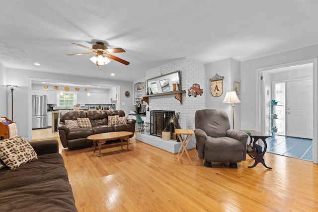 302 Peach Vly, Spartanburg, SC 29303 - living area featuring a ceiling fan, light wood-type flooring, a brick fireplace, and crown molding