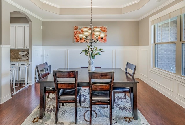 112 Murdock, Greer, SC 29651 - dining space featuring a raised ceiling, dark wood-type flooring, a decorative wall, a chandelier, and arched walkways