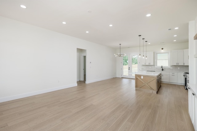 123 Stribling, Spartanburg, SC 29301 - kitchen featuring a center island, light wood-style floors, backsplash, light countertops, and open floor plan