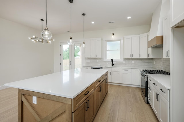 123 Stribling, Spartanburg, SC 29301 - kitchen featuring gas range, a sink, light wood-style flooring, tasteful backsplash, and light countertops