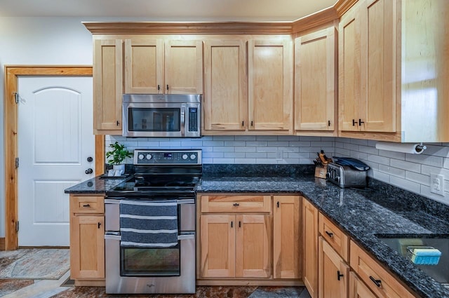 kitchen with stainless steel appliances, tasteful backsplash, dark stone countertops, a sink, and light brown cabinets