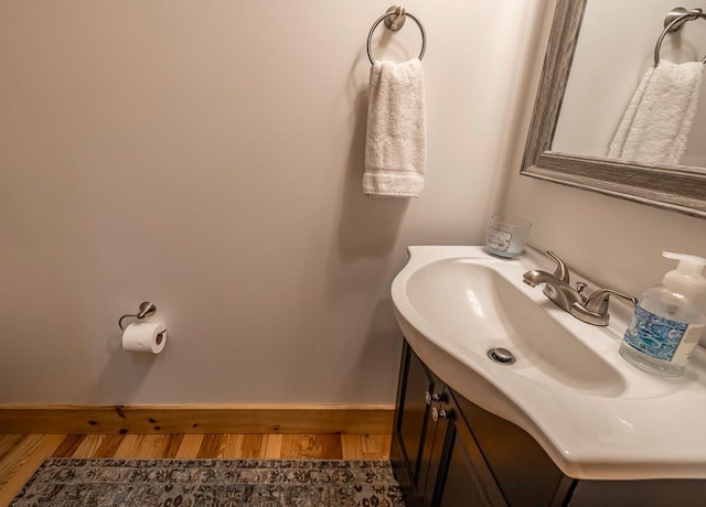 bathroom with wood finished floors, baseboards, and vanity