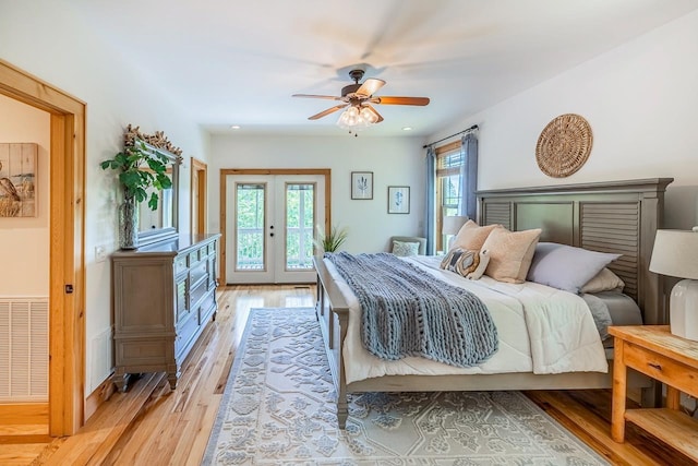 bedroom featuring light wood finished floors, access to outside, a ceiling fan, and french doors