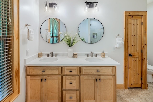 bathroom with toilet and double vanity