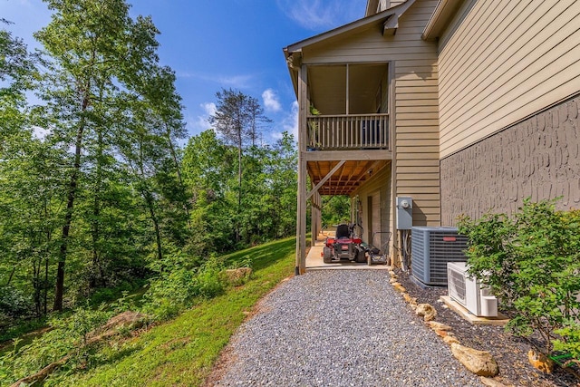 view of home's exterior with cooling unit, a patio, ac unit, and driveway