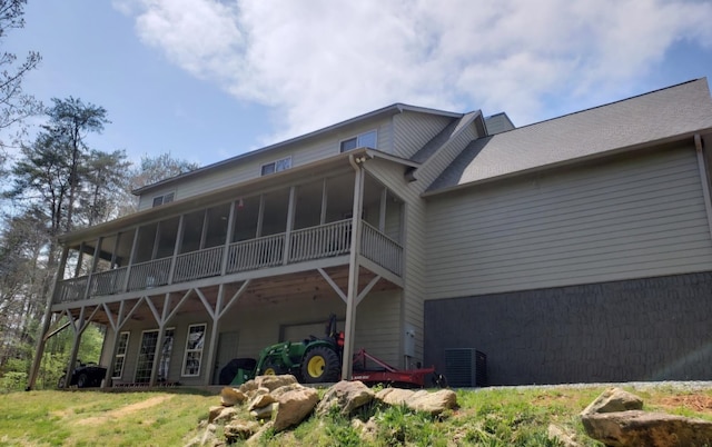 rear view of property featuring a sunroom and central AC unit