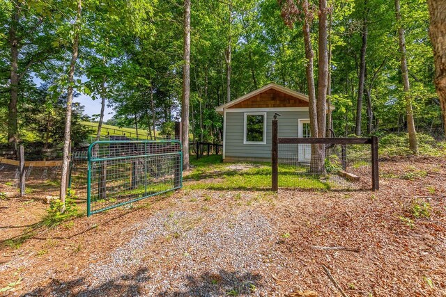view of outbuilding featuring fence and an outbuilding