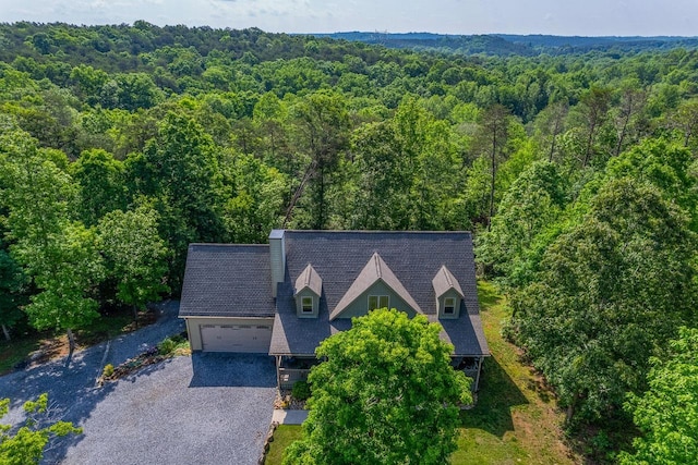 aerial view of property and surrounding area with a heavily wooded area