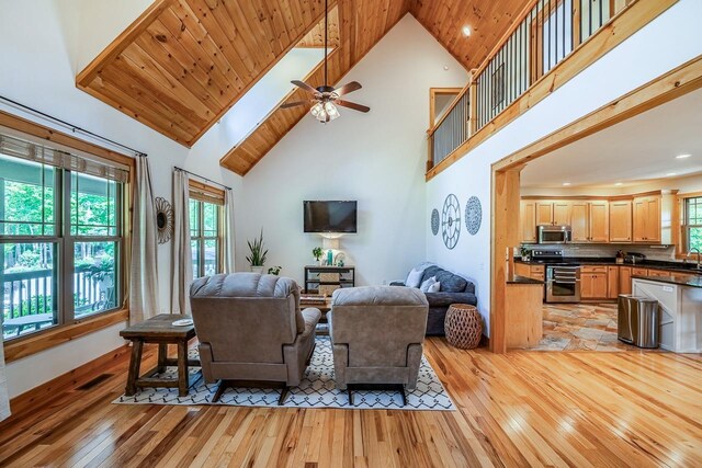 living room with light wood-style floors, high vaulted ceiling, ceiling fan, and recessed lighting