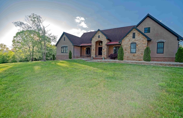 french country inspired facade with stone siding, a front lawn, and stucco siding