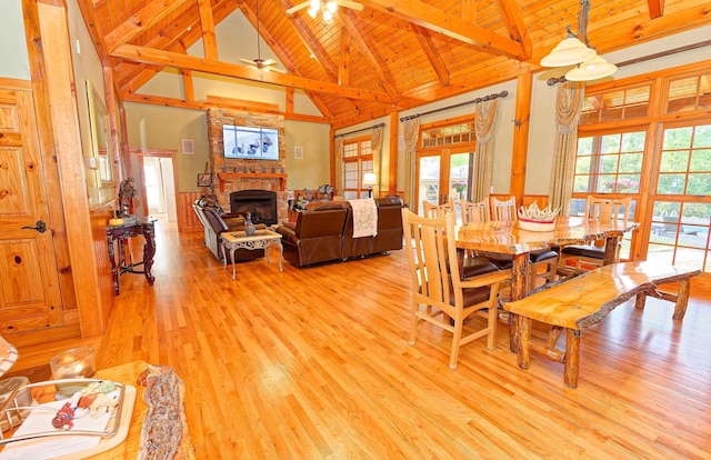 dining area with high vaulted ceiling, wood ceiling, beamed ceiling, light wood finished floors, and a fireplace