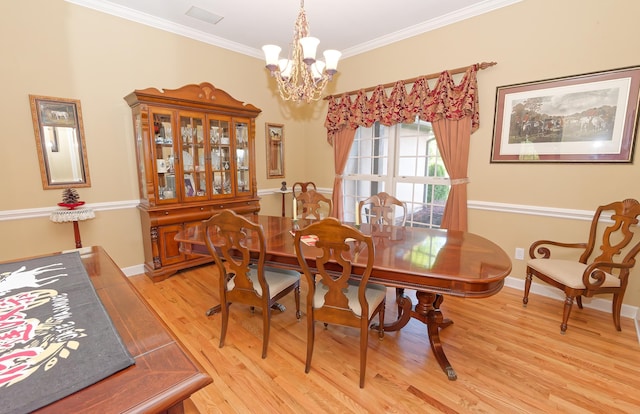 dining room featuring a chandelier, light wood-type flooring, ornamental molding, and baseboards