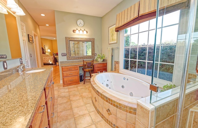 ensuite bathroom with a whirlpool tub, vanity, and recessed lighting
