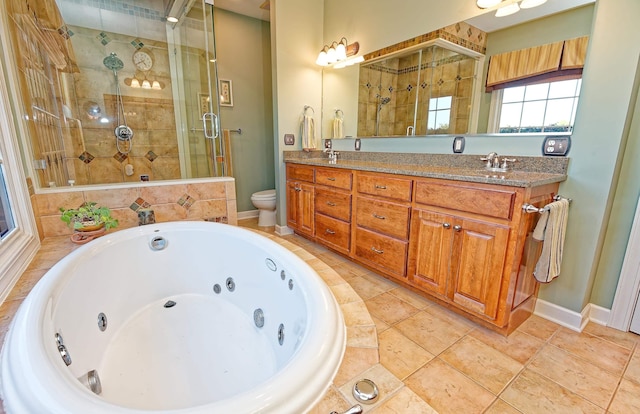 bathroom with a stall shower, a jetted tub, double vanity, toilet, and baseboards