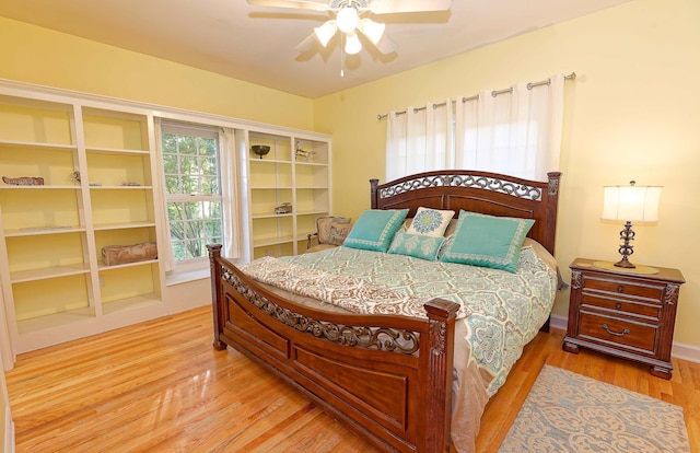 bedroom with wood finished floors, a ceiling fan, and baseboards