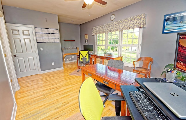 dining space featuring a ceiling fan, wood finished floors, a desk, and baseboards