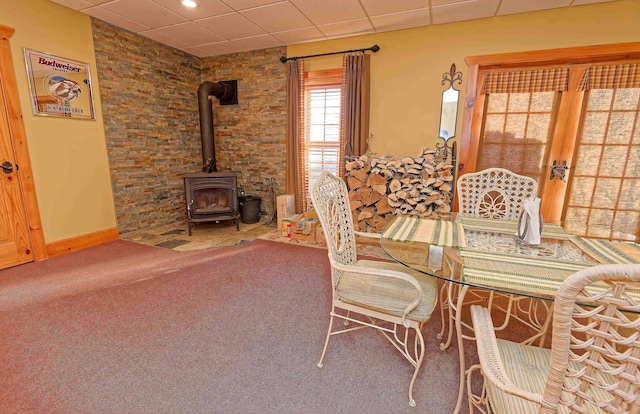 carpeted dining room featuring a wood stove