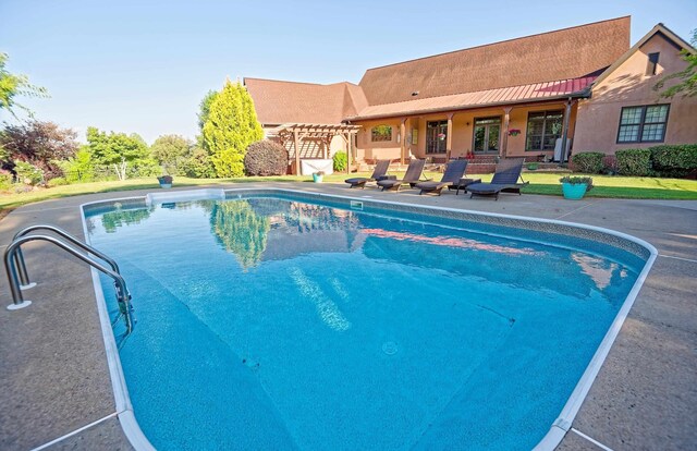 swimming pool with a patio and a pergola