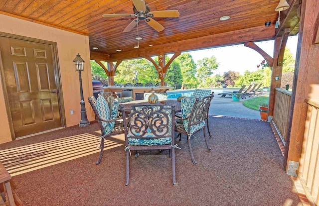 view of patio / terrace with ceiling fan, outdoor dining area, an outdoor pool, exterior kitchen, and a grill