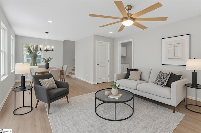 living area featuring stairs, a chandelier, light wood-style floors, ceiling fan, and recessed lighting