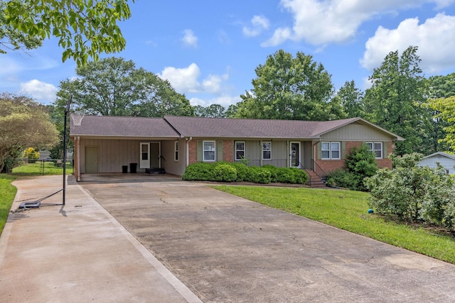 ranch-style house with concrete driveway, an attached carport, brick siding, and a shingled roof