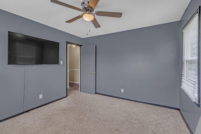 unfurnished bedroom featuring carpet floors, baseboards, and ceiling fan