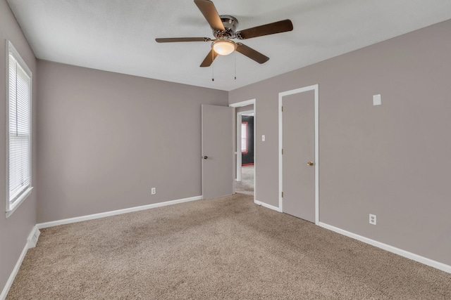 empty room featuring carpet flooring, a ceiling fan, and plenty of natural light
