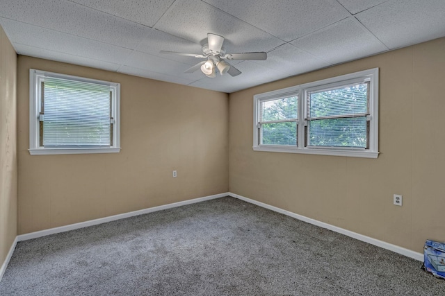 carpeted spare room with a ceiling fan and baseboards