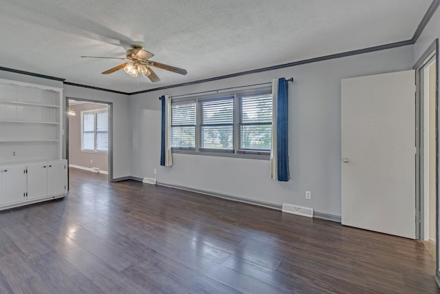 spare room with ceiling fan, crown molding, a textured ceiling, dark wood finished floors, and baseboards