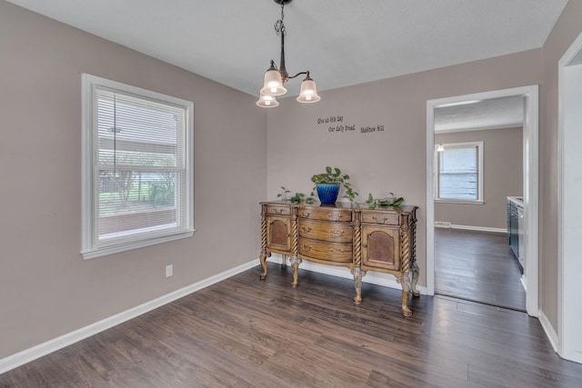 home office with a chandelier, dark wood-type flooring, and baseboards