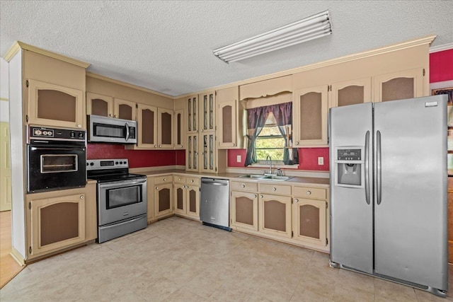 1006 Plantation, Anderson, SC 29621 - kitchen with appliances with stainless steel finishes, a sink, cream cabinets, a textured ceiling, and light countertops