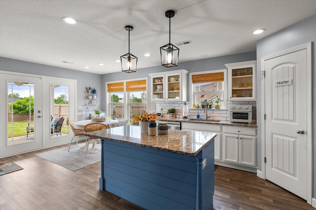 1101 Rosabella, Greer, SC 29651 - kitchen featuring a sink, white cabinets, glass insert cabinets, stainless steel dishwasher, and a center island