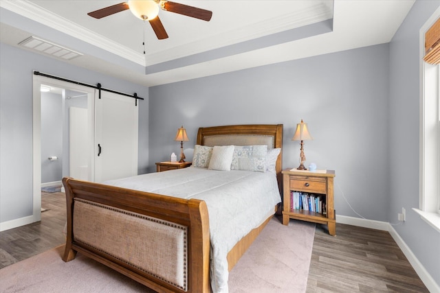1101 Rosabella, Greer, SC 29651 - bedroom with a barn door, wood finished floors, a raised ceiling, baseboards, and crown molding