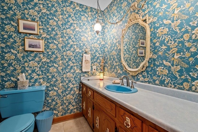 bathroom featuring baseboards, tile patterned flooring, wallpapered walls, vanity, and toilet