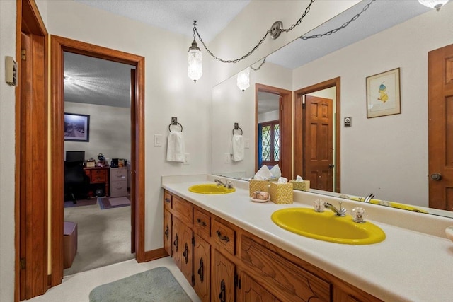 full bath featuring double vanity and a textured ceiling