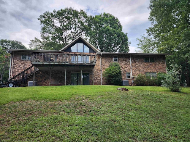 rear view of house featuring a deck, a lawn, brick siding, stairs, and central AC