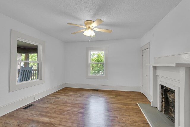 10 Beech, Spartanburg, SC 29303 - unfurnished living room featuring healthy amount of natural light, a high end fireplace, a ceiling fan, wood finished floors, and a textured ceiling