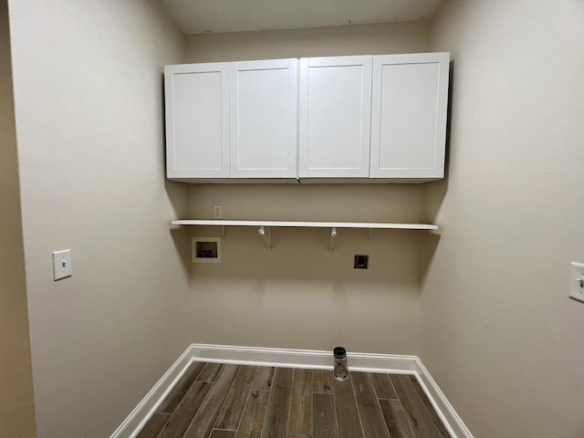 laundry area featuring electric dryer hookup, cabinet space, dark wood-type flooring, baseboards, and hookup for a washing machine