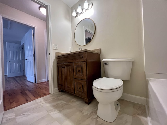 bathroom with baseboards, toilet, vanity, and marble look tiles