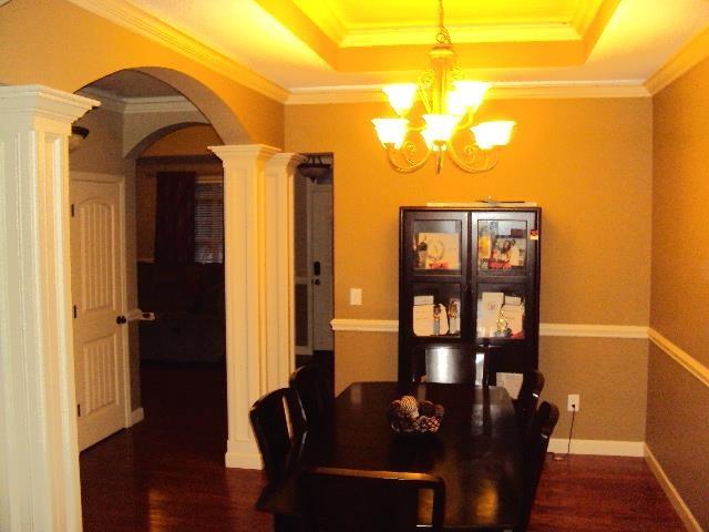 108 Dewfield, Boiling Springs, SC 29316 - dining room with decorative columns, arched walkways, a chandelier, dark wood-style floors, and a tray ceiling