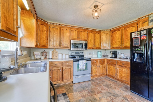 213 Mystic, Chesnee, SC 29323 - kitchen featuring stainless steel appliances, a sink, brown cabinets, light countertops, and a textured ceiling
