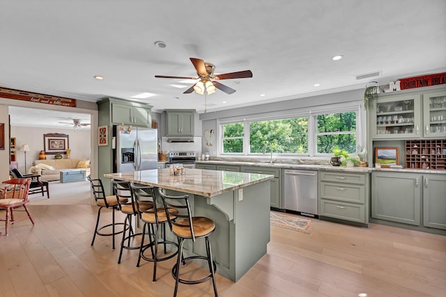 7 Hearthstone, Landrum, SC 29356 - kitchen with appliances with stainless steel finishes, a ceiling fan, light stone counters, green cabinetry, and light wood finished floors