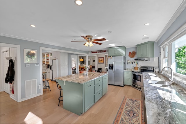 7 Hearthstone, Landrum, SC 29356 - kitchen with green cabinets, appliances with stainless steel finishes, ornamental molding, a sink, and a ceiling fan