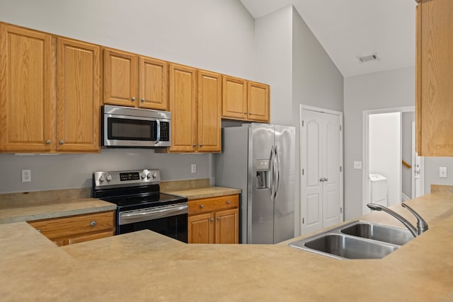 616 W Farrell, Woodruff, SC 29388 - kitchen with stainless steel appliances, a sink, washing machine and clothes dryer, light countertops, and high vaulted ceiling